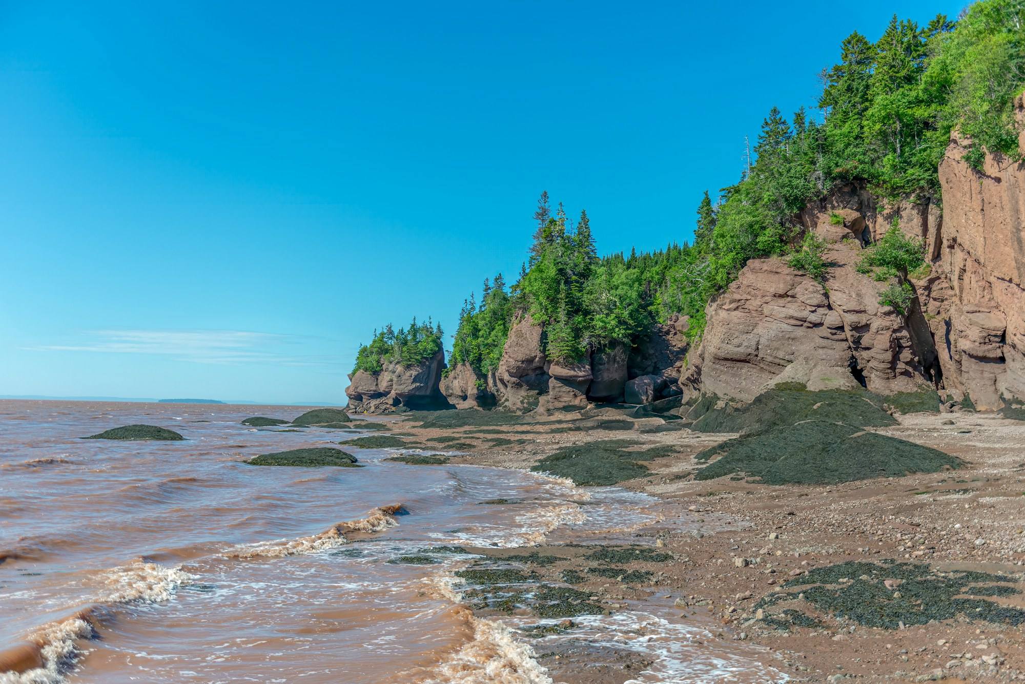 Red cliffs and a sandy beach on the Bay of Fundy coast