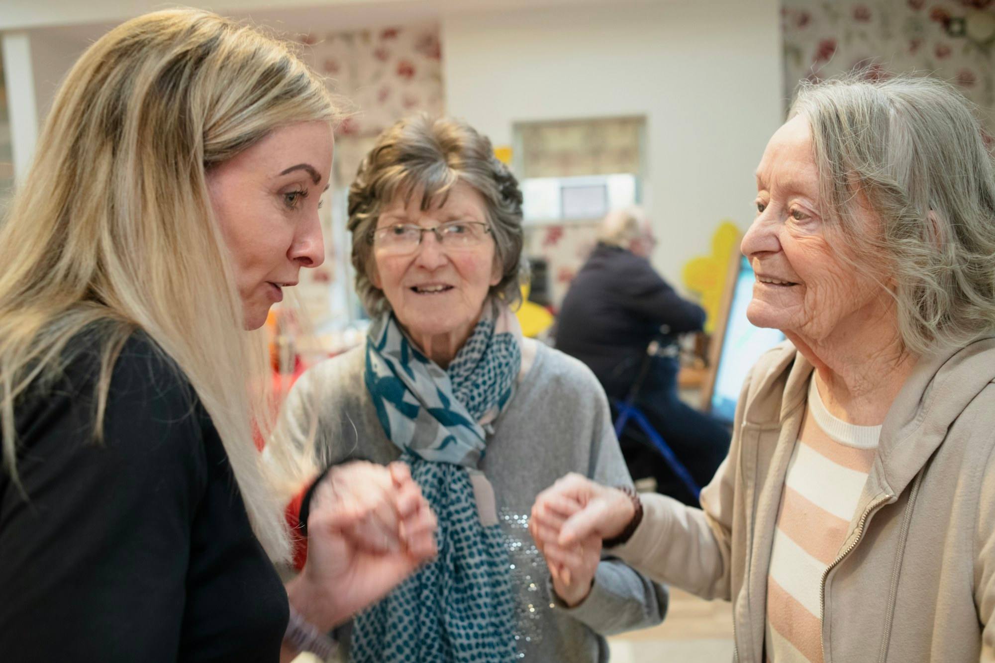 Three women greeting each other warmly indoors