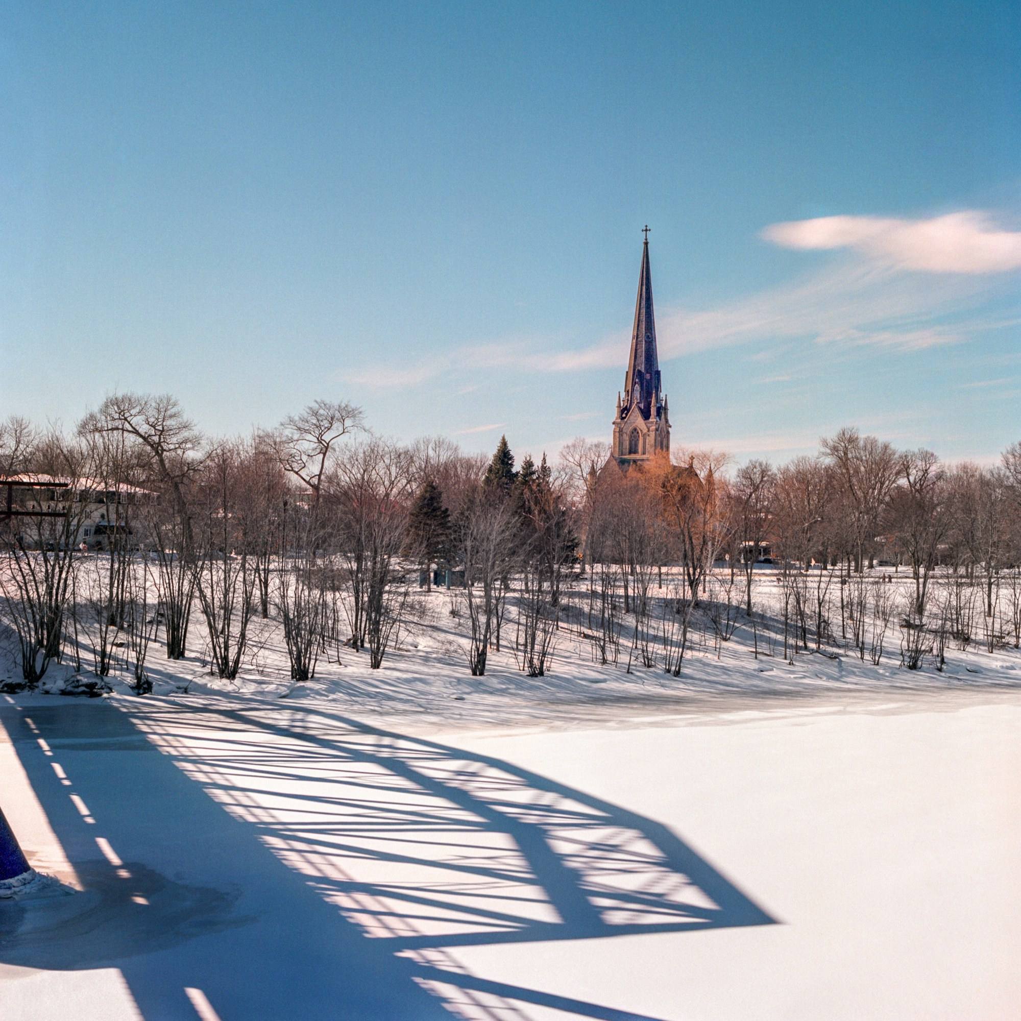 A church steeple beyond a snowy field in New Brunswick